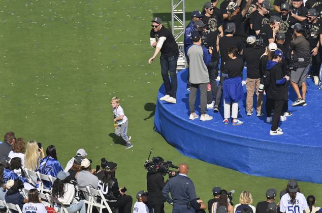 Los Angeles Dodgers first baseman Freddie Freeman (L) keeps an eye on his son Maximus as he celebrates their World Series win with teammates and fans following a parade at Dodger Stadium in Los Angeles on Monday, November 3, 2025. LAP2025110315 JIMxRUYMEN