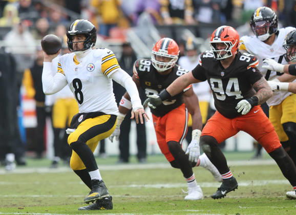 Pittsburgh Steelers quarterback Aaron Rogers (8) fakes a pass as he scrambles away from Cleveland Browns Myles Garrett (95) and Mason Graham (94) during the second quarter at Huntington Bank Field in Cleveland, Ohio on Sunday December 28, 2025.  CLE20251228111 AARONxJOSEFCZYK