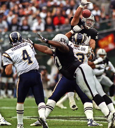 November 14, 1999 - Oakland, California, U.S - Oakland Raiders vs. San Diego Chargers at Oakland Alameda County Coliseum Sunday, November 14, 1999. Raiders beat Chargers 28-9. San Diego Chargers guard Aaron Taylor (73) blocks Oakland Raiders linebacker Greg Biekert (54) as quarterback Jim Harbaugh (4) attempts to pass ball over his head. Copyright: xAlxGolubx