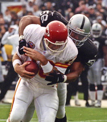 November 28, 1999 - Oakland, California, U.S - Oakland Raiders vs. Kansas City Chiefs at Oakland Alameda County Coliseum Sunday, November 29, 1999. Chiefs beat Raiders 37-34. Oakland Raiders linebacker Sam Sword (56) sacks Kansas City Chiefs quarterback Elvis Grbac Copyright: xAlxGolubx
