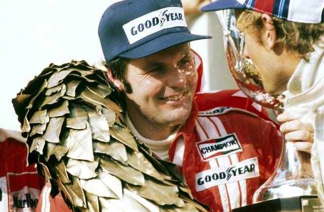 L to R): Alan Jones (AUS) Shadow, who claimed his first GP victory and the only GP win for the Shadow team, celebrates on the podium with Hans-Joachim Stuck (GER) Brabham, who finished in third position...Austrian Grand Prix, Rd 12, Osterreichring, Austria, 14 August 1977...BEST IMAGE. Copyright: xSuttonxMotorsportsx
