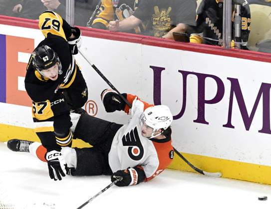 Pittsburgh Penguins right wing Rickard Rakell (67) and Philadelphia Flyers defenseman Jamie Drysdale (9) collide against the boards behind the goal during the overtime period of the 4-3 shootout win at PPG Paints Arena in Pittsburgh on Saturday, March 7, 2026. PIT2026030719 ARCHIExCARPENTER