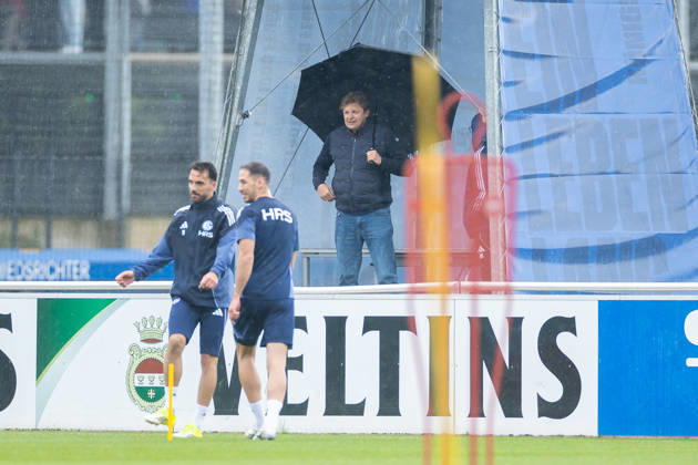 14.05.2026, Fussball, Training des FC Schalke 04. Direktor Profifussball Youri Mulder (FC Schalke 04) beobachtet das Training mit einem grossen Regenschirm. Gelsenkirchen Trainingsgelände FC Schalke 04 NRW Deutschland xRHR-FOTO YYx Copyright: RHR-FOTOx RHR-FOTO YY