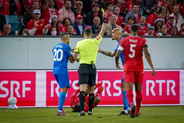 Fussball UEFA Nations League 2026 - 2027, 3. Spieltag - Schweiz vs Slowenien - Thermoplan Arena (Luzern): Schiedsrichter Ivan Kruzliak (Slowakei) zeigt Vanja Drkusic (Slowenien, 21) Gelbe Karte nach Foul an Johan Manzambi (Schweiz, 9) Copyright: xJOERANxSTEINSIEKx