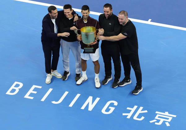 (261006) -- BEIJING, Oct. 6, 2026 -- Winner Novak Djokovic of Serbia pose for photos with his team staff after the awarding ceremony for the men s singles final at 2026 China Open tennis tournament in Beijing, China, Oct. 6, 2026. ) (SP)CHINA-BEIJING-TENNIS-CHINA OPEN-MEN S SINGLES-AWARDING CEREMONY(CN) ZhangxChenlin