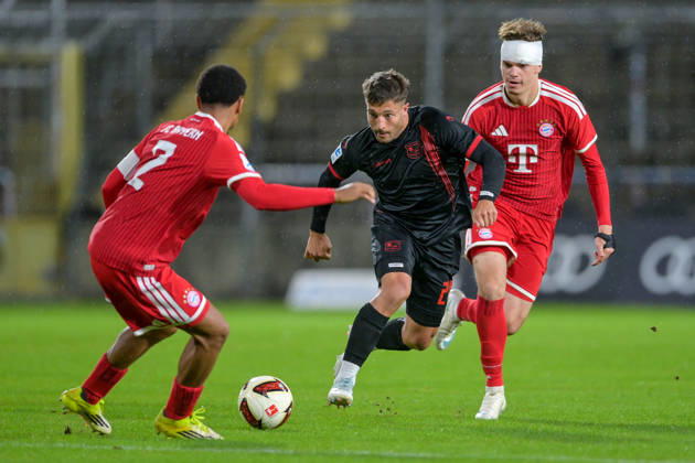 v.li.: Vincent Manuba Bayern Muenchen, FCB, 2) Moritz Mueller (Unterhaching, 24) Guido Della Rovere (Bayern Muenchen, FCB, 10) im Zweikampf, Duell, duel, tackle, Dynamik, Action, Aktion, 09.10.2026, München (Deutschland), Fussball, Regionalliga Bayern, FC Bayern München II - SpVgg Unterhaching