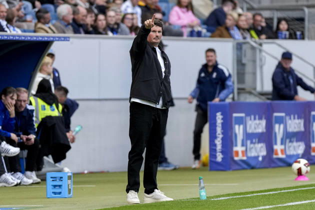 Merlin Polzin (Trainer, Cheftrainer, HSV), gibt Anweisungen, gestikuliert, mit den Armen gestikulieren, Freisteller, Ganzkörper, Einzelbild, Einzelfoto, Aktion, Action, am Spielfeldrand, an der Seitenauslinie, 10.10.2026, Sinsheim (Deutschland), Fussball, Bundesliga, TSG 1899 Hoffenheim - Hamburger SV, DFB DFL REGULATIONS PROHIBIT ANY USE OF PHOTOGRAPHS AS IMAGE SEQUENCES AND OR QUASI-VIDEO.