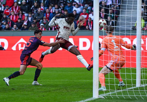 10.10.2026, xemx, Fussball 1.Bundesliga, FC Augsburg - Bayern München v.l. Aleksandar Pavlovic (FC Bayern Muenchen), Juma Bah (FC Augsburg), Manuel Neuer (FC Bayern Muenchen) Zweikampf, Aktion, action, battle for the ball (DFL DFB REGULATIONS PROHIBIT ANY USE OF PHOTOGRAPHS as IMAGE SEQUENCES and or QUASI-VIDEO) Augsburg