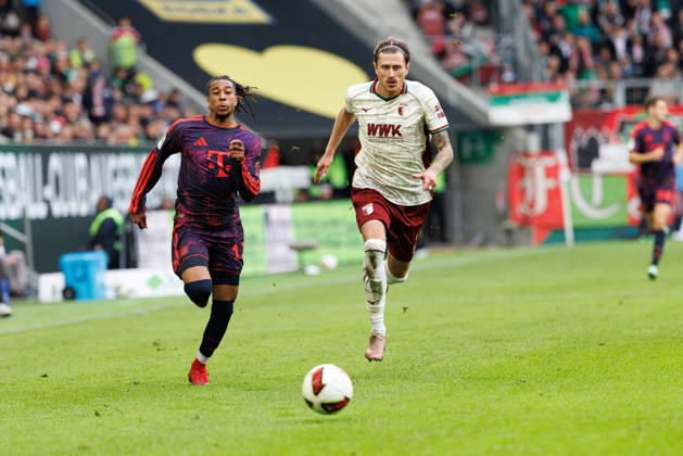 Michael Olise (17, FC Bayern München) und Calvin Brackelmann (2, FC Augsburg) beim Spiel zwischen FC Augsburg v FC Bayern München, Fussball, Herren, Bundesliga, 2026 2027, 5.Spieltag am 10.10.2026 in Augsburg, WWK ARENA. DFL and DFB regulations prohibit any use of photographs as image sequences and or quasi-video. Bayern Deutschland