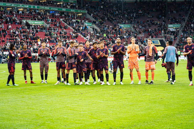 Die Spieler des FC Bayern Serge Gnabry (7 Bayern) ,Michael Olise (17 Bayern) Tom Bischof(8 Bayern) , Jonathan Tah (4 Bayern) , Aleksandar Pavlovic (45 Bayern) , Josip Stanisic (44 Bayern) , Lennart Karl (42 Bayern) Manuel Neuer (1 Bayern) , Jonas Urbig (40 Bayern) , Joshua Kimmich (6 Bayern) und Harry Kane (9 Bayern) stehen in der Kurve nach dem Bundesligaspiel FC Augsburg - FC Bayern München am 10.10.2026.