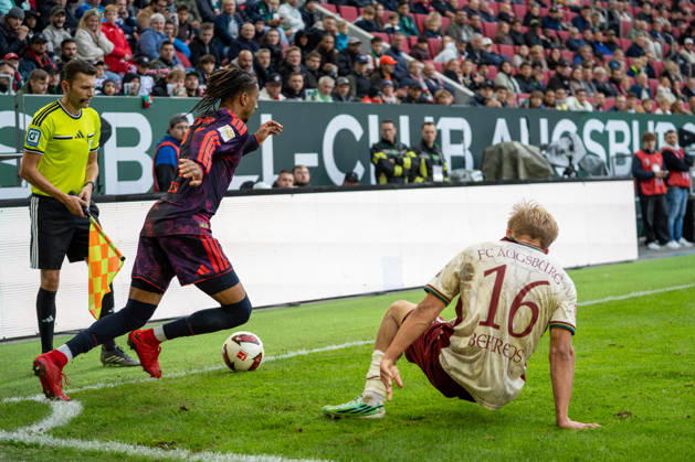 Michael Olise (17 Bayern) und Hennes Behrens (16 Augsburg) in Aktion beim Bundesligaspiel FC Augsburg - FC Bayern München am 10.10.2026.