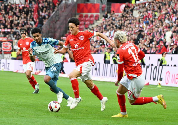 Fussball-Bundesliga - Saison 2026 2027 Mewa-Arena Mainz - 10.10.2026 1. FSV Mainz 05 (mz) - Bayer Leverkusen (lev) 3:4 Malik TILLMAN (Bayer Leverkusen), li, Jae-Sung LEE(1. FSV Mainz 05), mi, Benedikt HOLLERBACH (1. FSV Mainz 05) DFL REGULATIONS PROHIBIT ANY USE OF PHOTOGRAPHS AS IMAGE SEQUENCES AND OR QUASI VIDEO EDITORIAL USE ONLY NATIONAL AND INTERNATIONAL NEWS AGENCIES OUT Fussball-Bundesliga - 1. FSV Mainz 05