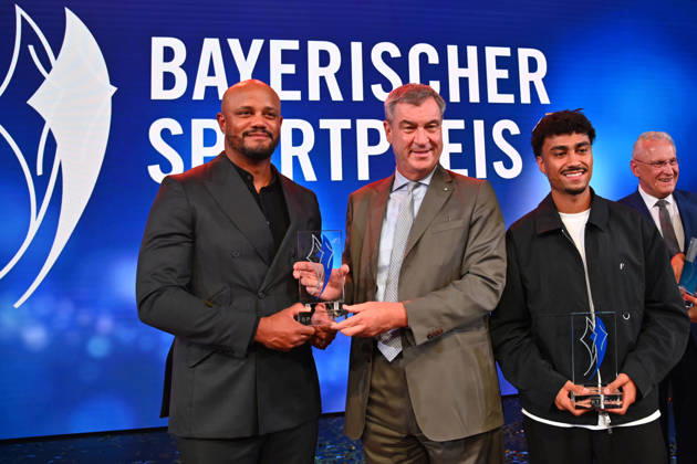 Trainer Vincent KOMPANY (Bayern Muenchen) mit dem Ehrenpreis des Bayerischen Mininsterpraesidenten Markus SOEDER,re:Nathaniel BROWN (Bayern Muenchen), Joachim HERRMANN (Innenminister Bayern).. Bayerischer Sportpreis 2026 in der BMW Welt, Roter Teppich,Red Carpet am 10.10.2026