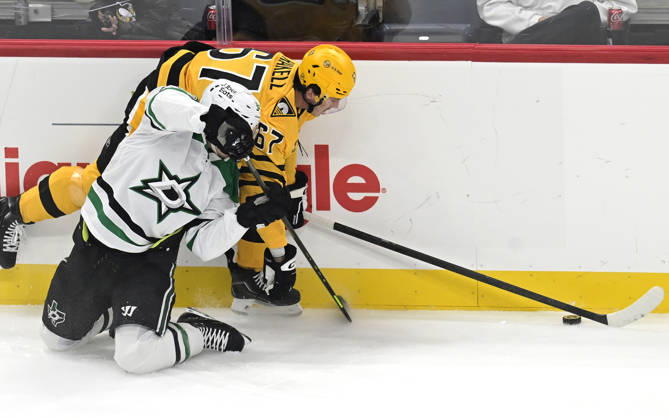 Pittsburgh Penguins right wing Rickard Rakell (67) plays the puck pass Dallas Stars center Justin Hryckowian (49) during the first period at PPG Paints Arena in Pittsburgh on Saturday, October, 10 2026.  PIT2026101001 ARCHIExCARPENTER