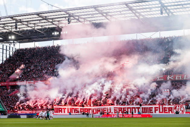 KOELN, GERMANY - OCTOBER 11: Tifo of 1. FC Koeln fans while burning pyrotechnics bengalos during the Bundesliga match between 1. FC Koeln vs. Borussia Moenchengladbach at Rheinenergie-Stadion on matchday 5 of the 1. Bundesliga on October 11, 2026 in Koeln, Germany. DFL REGULATIONS PROHIBIT ANY USE OF PHOTOGRAPHS AS IMAGE SEQUENCES AND OR QUASI-VIDEO. Wat uns aandriev, brennt wie fueer What drives us, burns like fire. North Rhine Westphalia Germany Copyright: xSteffiexWunderlx