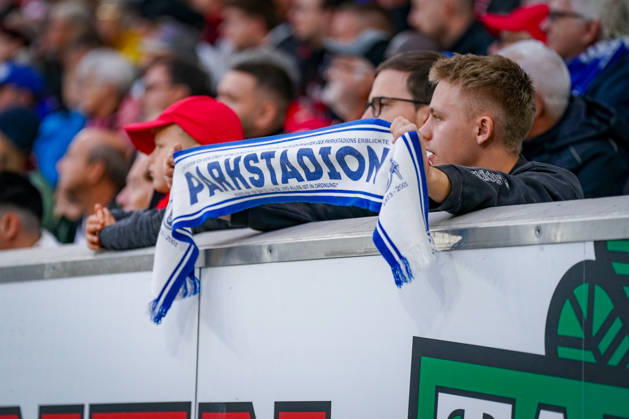 Deutschland: Fußball Bundesliga 2026 - 2027, 5. Spieltag - SC Freiburg - FC Schalke 04 - Europa-Park-Stadion (Freiburg): Junger Fan des FC Schalke 04 hält einen blau-weissen Fanschal mit der Aufschrift PARKSTADTION auf der Tribüne des Europa-Park Stadions beim Auswärtsspiel gegen den SC Freiburg hoch. Schalke 04, S04, Königsblau, Parkstadion, Stadiongeschichte, Tradition, Nostalgie, Fankultur, Fanszene, Gästefans, Auswärtsfans, Fanschal, Fanartikel, Zuschauer, Tribüne, Fussball, Bundesliga, SC Freiburg, SCF, Gelsenkirchen, Freiburg, Stadion, Innenansicht, Detailaufnahme. Copyright: xJOERANxSTEINSIEKx