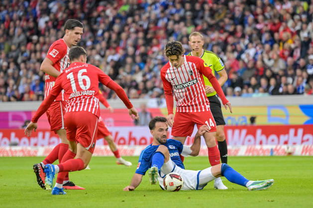 Kenan Karaman (FC Schalke 04, 19) sitzt am Boden mit Ball und im Duell mit VIgor Matanovic (SC Freiburg, 31), Yannik Engelhardt (SC Freiburg, 16), Yuito Suzuki (SC Freiburg, 14) GER, SC Freiburg vs Schalke 04, Fussball, Bundesliga, 5. Spieltag, Saison 2026 2027, 11.10.2026 DFL DFB REGULATIONS PROHIBIT ANY USE OF PHOTOGRAPHS AS IMAGE SEQUENCES AND OR QUASI-VIDEO GER, SC Freiburg vs Schalke 04, Fussball, Bundesliga, 5. Spieltag, Saison 2026 2027, 11.10.2026 Freiburg Copyright: xEibner-Pressefotox EP_THS