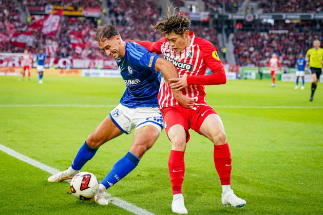 Deutschland: Fußball Bundesliga 2026 - 2027, 5. Spieltag - SC Freiburg - FC Schalke 04 - Europa-Park-Stadion (Freiburg): Nikola Katic (FC Schalke 04, 25) und Yuito Suzuki (SC Freiburg, 14) im Zweikampf Copyright: xJOERANxSTEINSIEKx