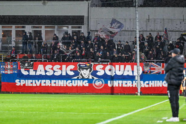 Unterhachinger Fans schwenken Fahnen und machen Stimmung, Fans, Publikum, Zuschauer, Stimmung, Atmosphaere, Stadion, 13.10.2026, Unterhaching (Deutschland), Fussball, Regionalliga Bayern, SpVgg Unterhaching - TSV 1882 Landsberg