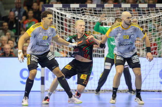 14.10.2026, xtgx, Handball Champions Legaue, SC Magdeburg - Industria Kielce emspor, v.l. Theo Monar (Kielce, 97), Magnus Saugstrup (Magdeburg, 23), Artsem Karalek (Kielce, 50) Zweikampf, Duell, Kampf, tackle Magdeburg