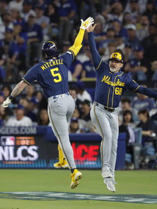 Milwaukee Brewers Garrett Mitchell (5) celebrates with third base coach Matt Erickson (68) after hitting a solo home run against the the Los Angeles Dodgers in the seventh inning of the MLB, Baseball Herren, USA National League Championship Series playoffs at Dodger Stadium in Los Angeles, California, on Wednesday, October 14, 2026.  LAP20261014731 CAROLINExBREHMAN