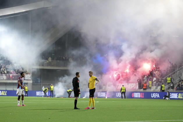 LKS 20261015 KuPS captain Petteri Pennanen (R) talks with referee Ishmael Barbara as fans light flares in the stands during the football UEFA Conference League League Phase match between KuPS Kuopio and Trabzonspor in Tampere, Finland, on October 15, 2026. - MIKA KYLMÄNIEMI Tampere Finland 5Ec8e_6GBT8  Copyright: xMikaxKylmäniemix 5Ec8e_6GBT8