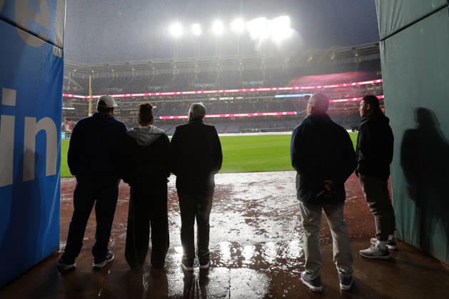 People watch as a heavy rain falls before the start of game four of the MLB, Baseball Herren, USA American League Championship Series between the Tampa Bay Rays and the Cleveland Guardians at Progressive Field in Cleveland, Ohio, on Friday, October 16, 2026. The 8pm ET start of the game has been delayed due to the weather.  CLE20261016701 AARONxJOSEFCZYK