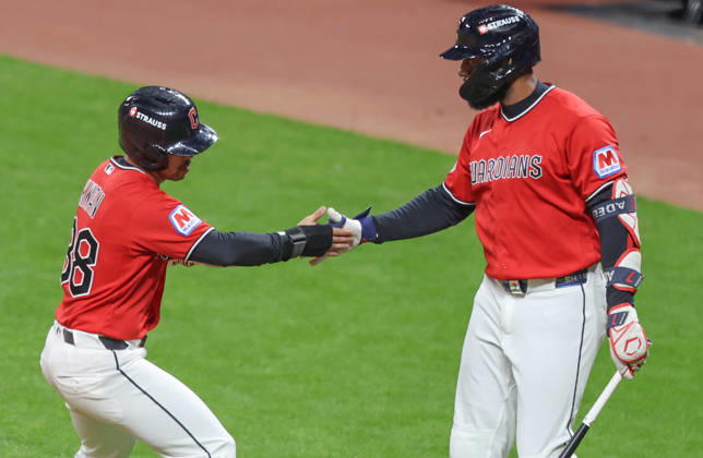 Cleveland Guardian Steven Kwan (38) is congratulated by Jo Adell after scoring on a hit by Chase DeLauter in the first inning against the Tampa Bay Rays during game four of the MLB, Baseball Herren, USA American League Championship Series at Progressive Field in Cleveland, Ohio, on Saturday, October 17, 2026.  CLE20261017706 AARONxJOSEFCZYK