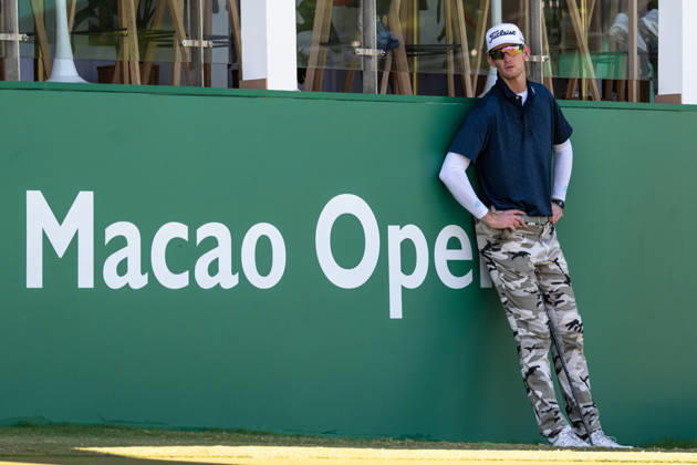 October 18, 2026, Macau, Macao Sar, China: Charles PORTER from the USA takes the tied lead on -14 Par with a stunning -9 Par final round. PORTER and his caddy hide from the heat in the shade of the hospitality stand on the 18th green. Macau Open Golf 2026 Final Round. Macau China - ZUMAr144 20261018_zap_r144_046 Copyright: xJaynexRussellx