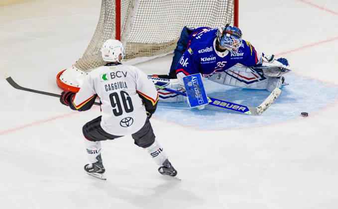 Ice hockey, Eishockey National League Regular Season - EHC Kloten vs Lausan Kloten, Switzerland, 20th Oct 2026: Goaltender 35 Davide Fadani (Kloten) is busy saving the puck. 96 Drake Caggiula (Lausanne) sees the rebound. Copyright: xAndreasxHaasx