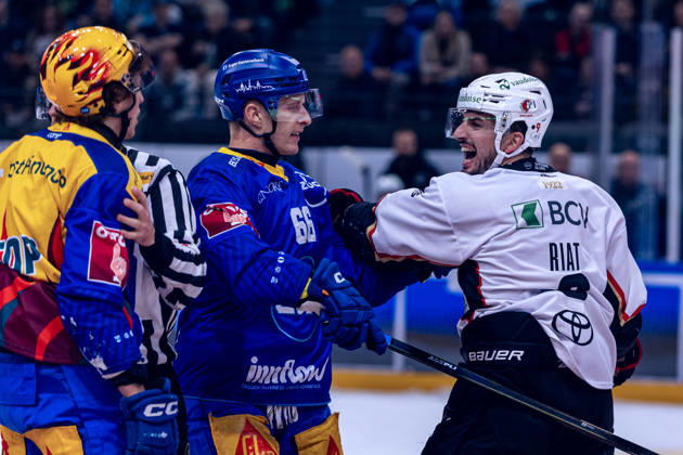 Damien Riat 9 (Lausanne HC) will von Topscorer Vinzenz Rohrer (EV Zug) nicht ablassen, nach dessen Check gegen Philipp Kurashev 23 (Lausanne HC) - 23.10.2026 - National League, Regular Season, Eishockey, OYM hall, Zug: EV Zug - Lausanne HC . (Bild von Copyright: xJustPictures.ch PhilippxHegglinx