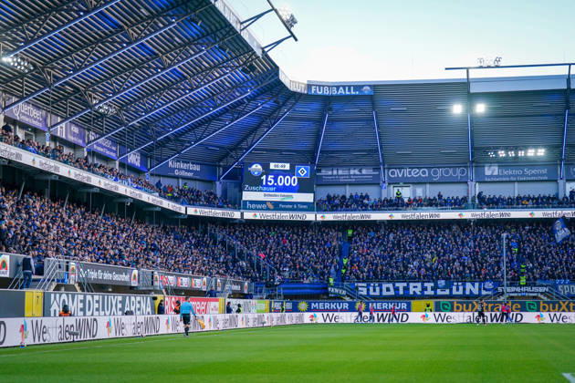 Deutschland: Fussball Bundesliga 2026 - 2027, 7. Spieltag - SC Paderborn vs Hamburger SV - Home-Deluxe-Arena (Paderborn): Totale der Home-Deluxe-Arena in Paderborn, Innenansicht mit voll besetzten Tribünen und Stadionanzeige 15.000 Zuschauer beim Bundesligaspiel SC Paderborn 07 gegen Hamburger SV (HSV). Ausverkauftes Stadion, Zuschauerzahl, Fans, Fankurve, Stadiondach, Flutlicht, Spielfeld, Schiedsrichterassistent, Anzeigetafel, Sportstätte, Fussball, Bundesliga, Werbung, Sponsoren, Werbebanden, WestfalenWIND, Merkur, buXtrade, avitea group, Klinkerbau Göllner. Copyright: xJOERANxSTEINSIEKx
