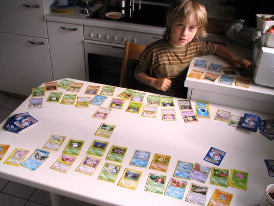 Kleiner Junge präsentiert stolz seine Pokemonkarten-Sammlung