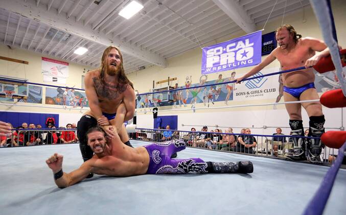 October 15, 2016 - Oceanside, California, USA - 10 15 2016_Oceanside, CA_SoCal Pro Wrestling s Rumble in Oceanside event at the Oceanside Boys & Girls Club gymnasium. Wrestler Mike Camden twists the arm of opponent Ricky Mandel as Mandel s tag-team partner Tommy Wilson watches._Photo by Oceanside USA - ZUMAn47_