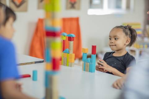 Girl looking at tower of building blocks in kindergarten model released Symbolfoto property released  ZEF15437