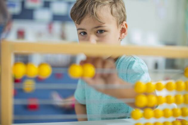 Boy in kindergarten using abacus model released Symbolfoto property released  ZEF15446