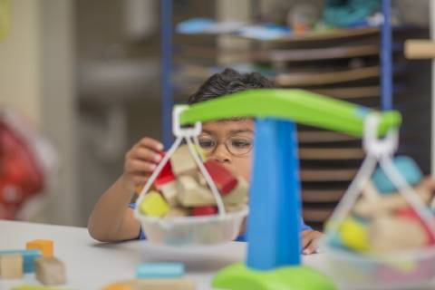 Boy playing with toy scales in kindergarten model released Symbolfoto property released  ZEF15482