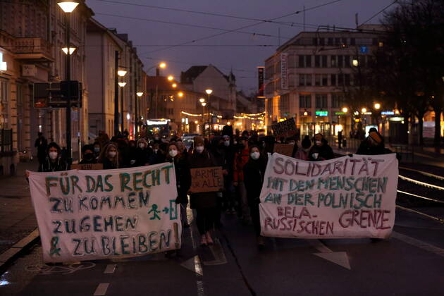 Demonstranten laufen mit Bannern in der Friedrich-Ebert-Straße während einer Seebrücke-Demonstration für die Aufnahme von Flüchtlingen aus dem polnisch-belarussischen Grenzgebiet, Potsdam, 18. Dezember 2021. Seebrücke-Demo in Potsdam