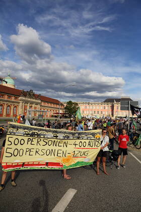 Demonstranten stehen mit Banner 500 Personen 400 Autos 500 Personen 1 Zug auf der Breiten Straße im Rahmen der Students for Future Fahrraddemo Ohne Kerosin nach Berlin bei einem Zwischenstopp in Potsdam, 31. August 2022. Students for Future Ohne Kerosin nach Berlin