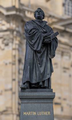 Denkmal des Reformators Martin Luther (1483-1546) mit einer Bibel in der Hand vor der Frauenkirche am Neumarkt in Dresden. Am 31. Oktober feiern evangelische Christen den Reformationstag. Martin Luther soll am 31. Oktober 1517 seine kirchenkritischen 95 Thesen an die Tür der Schlosskirche in Wittenberg (Sachsen-Anhalt) geschlagen haben. Dieses Datum gilt als Beginn der Reformation der Kirche. Dresden Sachsen Deutschland