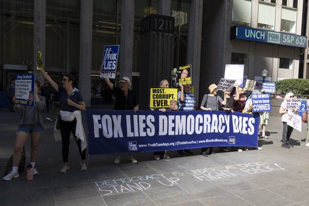 October 7, 2025, New York, New York, USA: Demonstrators denouncing Fox News as extremist right-wing propaganda in support of President Trump s administration hold a banner and signs that read FOX LIES DEMOCRACY DIES MOST. CORRUPT. EVER. with an image of President Trump Rupert STOP YOUR MONSTER NO TROOPS IN OUR CITIES! FOX VIEWERS You ve been CONNED outside of News Corp s Fox News Channel in midtown Manhattan. Chalking on the plaza reads DEMOCRACY IS UNDER ATTACK STAND UP FIGHT BACK! Protesters with the activist groups Rise & Resist and Truth Tuesdays come to Fox News weekly for a peaceful demonstration calling for truth in journalism and denouncing authoritarianism, oligarchy, fascism, and Trump s agenda. New York USA - ZUMAr174 20251007_znp_r174_001 Copyright: xGinaxMxRandazzox
