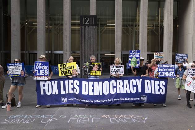 October 7, 2025, New York, New York, USA: Demonstrators denouncing Fox News as extremist right-wing propaganda in support of President Trump s administration hold a banner and signs that read FOX LIES DEMOCRACY DIES MOST. CORRUPT. EVER. with an image of President Trump Rupert STOP YOUR MONSTER NO TROOPS IN OUR CITIES! FOX POISONS AMERICA FOX VIEWERS You ve been CONNED outside of News Corp s Fox News Channel in midtown Manhattan. Chalking on the plaza reads DEMOCRACY IS UNDER ATTACK STAND UP FIGHT BACK! Protesters with the activist groups Rise & Resist and Truth Tuesdays come to Fox News weekly for a peaceful demonstration calling for truth in journalism and denouncing authoritarianism, oligarchy, fascism, and Trump s agenda. - ZUMAr174 20251007_znp_r174_006 Copyright: xGinaxMxRandazzox