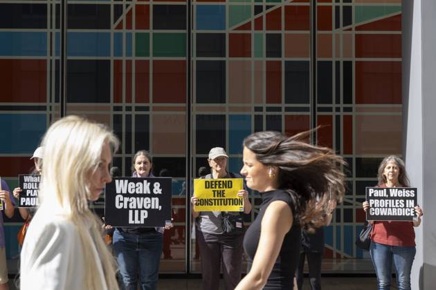 October 7, 2025, New York, New York, USA: Demonstrators with the activist group Rise and Resist hold signs that read Weak and Craven, LLP DEFEND THE CONSTITUTION Paul, Weiss PROFILES IN COWARDICE outside of the offices of Paul, Weiss, Rifkind, Wharton and Garrison LLP as lunchtime crowds pass in midtown Manhattan. Protesters stage a peaceful demonstration to denounce the law firm s agreement to provide millions in pro bono legal work to initiatives from President Trumpâ€⠢s agenda and to abandon diversity, equity, and inclusion (DEI) policies. New York USA - ZUMAr174 20251007_znp_r174_043 Copyright: xGinaxMxRandazzox