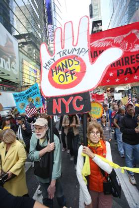 October 18, 2025, New York City, New York, USA: A man holds a sign that says Hey Trump, Hands off NYC during the No Kings protest in New York City on Oct. 18, 2025. Tens of thousands of people hit New York City streets to protest Donald Trump, autocracy, ICE and immigrant deportations. More than 2,500 similar protests took place nationwide. New York City USA - ZUMAk45_ 20251018_zaf_k45_058 Copyright: xKristaxKennellx