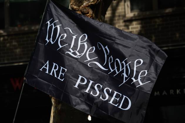 October 18, 2025, New York, New York, USA: Protester holds black flag that reads, â€oeWe The People Are Pissed†in the New York City No Kings protest in opposition to measures Donald Trump has taken to install authoritarian style rule. New York USA - ZUMAl171 20251018_znp_l171_035 Copyright: xEdnaxLeshowitzx