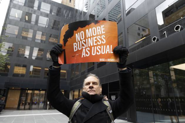 October 28, 2025, New York, New York, USA: A demonstrator holds a sign that reads NO MORE BUSINESS AS USUAL with an image of a smokestack at a rally and picket against the Governor s recent climate policy announcement outside Hochul s New York City office in Midtown Manhattan. Climate activists say President Trump isn t a king and Governor Hochul isn t a Queen after she announced plans to delay the implementation of a state law set to begin January 1st that ends gas use in new construction. Demonstrators also denounce what they call the Governor s lurch to Trumpism for fast tracking the permitting for a fracked gas pipeline. The peaceful protest is organized by New York Communities For Change, Food and Water Watch NY and NYPIRG. New - ZUMAr174 20251028_znp_r174_006 Copyright: xGinaxMxRandazzox