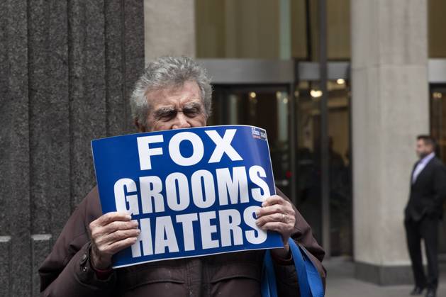 October 28, 2025, New York, New York, USA: A demonstrator holds a sign that reads FOX grooms HATERS joining peaceful protesters outside of News Corp s Fox News Channel in midtown Manhattan. People with the activist groups Rise & Resist and Truth Tuesdays call for truth in journalism and denounce ICE, Federal troops sent to cities and Fox News as extremist right-wing propaganda in support of President Trump s administration. New York USA - ZUMAr174 20251028_znp_r174_025 Copyright: xGinaxMxRandazzox