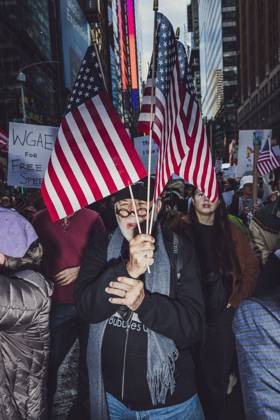 October 18, 2025, New York, New York, USA: A demonstrator holds American flags while marching down Manhattan during the second No Kings protest. An estimated 350,000 came to this event. New York USA - ZUMAp287 20251018_znp_p287_007 Copyright: xFarhadxParsax