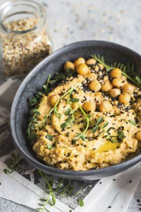Kichererbsenhummus in der schwarzen Schale, dekoriert mit Sesamsamen und Kichererbsengrün. Vegane Rezepte, Gerichte auf pflanzlicher Basis. Konzept für umweltfreundliches Wohnen. Biologische Lebensmittel. Vegetarische Küche Chickpeas hummus in the black bowl decorated with sesame seeds and chickpeas greens. Vegan recipes, plant-based dishes. Green living concept. Organic food. Vegetarian cuisine Copyright: imageBROKER NataliiaxZhekova ibxiqx16147411.jpg