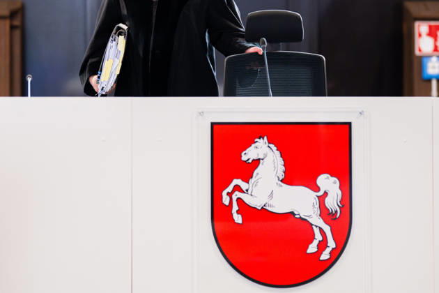 29.04.2026 - Plädoyers der Staatsanwaltschaft beim Prozess gegen Daniela Klette, die 15 Jahre Haft fordert. Der mutmaßlichen RAF-Terroristin wird versuchter Mord und die Beteiligung an bewaffneten Raubüberfällen vorgeworfen, die in einer umgebauten Reithalle vor dem Landgericht Verden (Aller) in Niedersachsen verhandelt wird. Im Bild: Logo des Bundeslandes Niedersachsen im Gerichtssaal vor Richter Lars Engelke. , Verden Niedersachsen Deutschland -